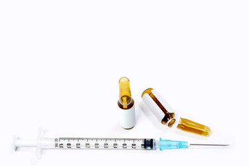 3 ml. brown ampules of drug is opened and plastic syringes with medical needle on white background.