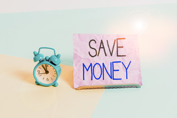 Handwriting text writing Save Money. Conceptual photo store some of your cash every month to use them sometime later Mini size alarm clock beside a Paper sheet placed tilted on pastel backdrop