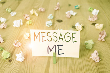 Conceptual hand writing showing Message Me. Concept meaning To ask someone to send you a short text from one mobile device Colored crumpled papers wooden floor background clothespin