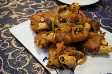 Shanghai style Deep fried Pork knuckles with soy sauce and stir fry onion and chilis.