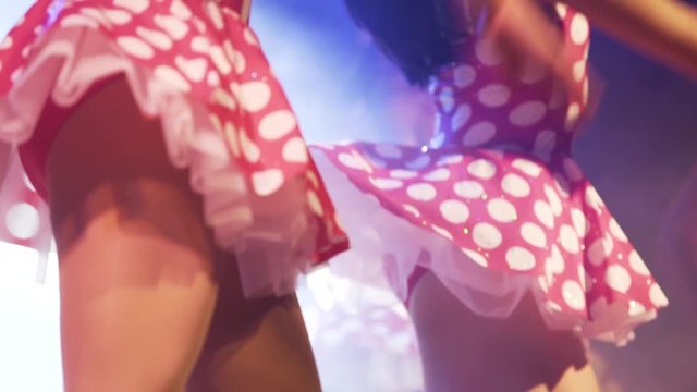 close up dancers with mini red skirts with white dots, close up dancers legs , girls dancing , beautiful happy close up legs