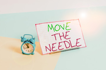 Handwriting text writing Move The Needle. Conceptual photo Make a noticeable difference in something do better Mini size alarm clock beside a Paper sheet placed tilted on pastel backdrop