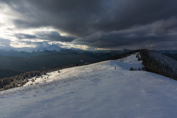 Fogs and clouds in winter Ukrainian Carpathians with snow-covered trees and mountain peaks