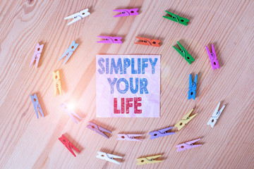 Conceptual hand writing showing Simplify Your Life. Concept meaning Manage your day work Take the easy way Organize Colored crumpled papers wooden floor background clothespin