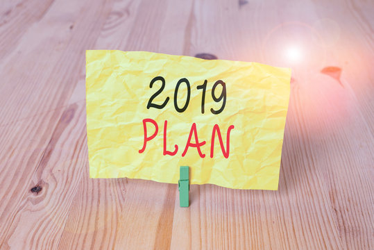 Conceptual hand writing showing 2019 Plan. Concept meaning Challenging Ideas Goals for New Year Motivation to Start Wooden floor background green clothespin groove slot office