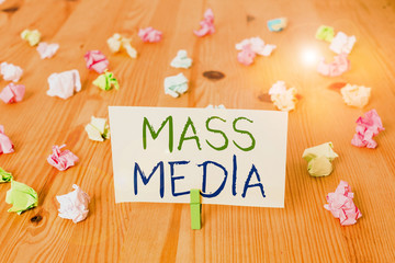 Conceptual hand writing showing Mass Media. Concept meaning Group showing making news to the public of what is happening Colored crumpled papers wooden floor background clothespin