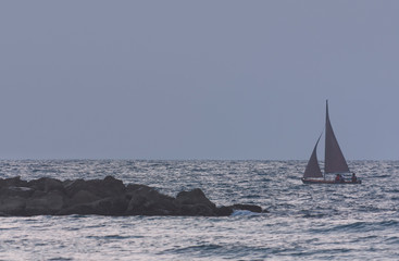 Seascape with sailing boat at dusk as background