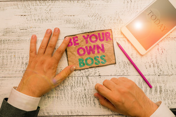 Obraz premium Text sign showing Be Your Own Boss. Business photo text Entrepreneurship Start business Independence Selfemployed Hand hold note paper near writing equipment and modern smartphone device