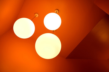 warm color bulb light hang on the orange ceiling