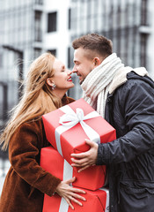 Love couple exchanging gifts outdoors. Romantic surprise for Christmas