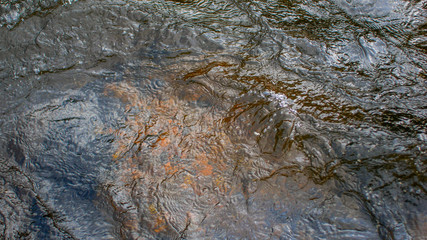 the surface of the water on the mountain river and the rocks on the bottom