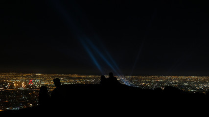  People Silhouette Watching Beams of Light from Spotlights at Night