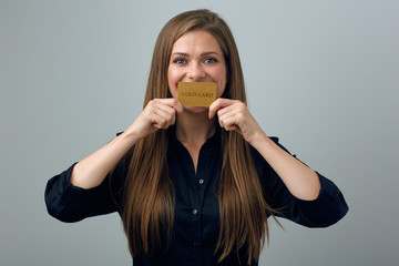 Woman in black dress covered mouth with credit card.