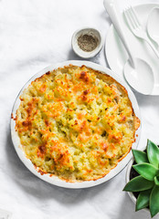 Creamy chicken, cauliflower, leek pie with crispy potato cheese topping on light background, top view. Comfort food