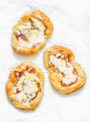 Puff pastry, ham, mozzarella cheese breakfast pizza on a light background, top view