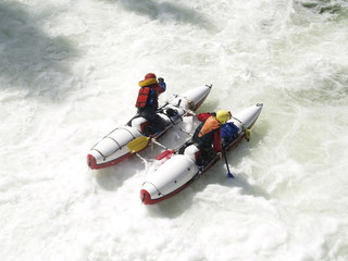 Fototapeta na wymiar Rafting on a water catamaran on a stormy river