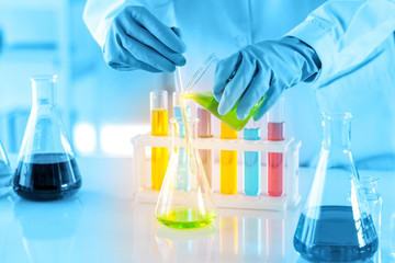 scientist with equipment and science experiments, laboratory glassware containing chemical liquid for research or analyzing a sample into test tube in laboratory