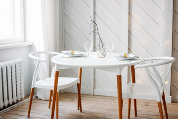 Festive table set for two, minimalistic Christmas decor. Scandinavian interior