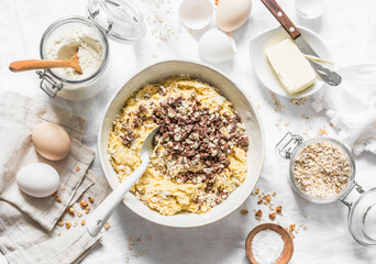 Cooking banana oatmeal cake with white and milk chocolate. Ingredients for the cake on a light background, top view. Flat lay