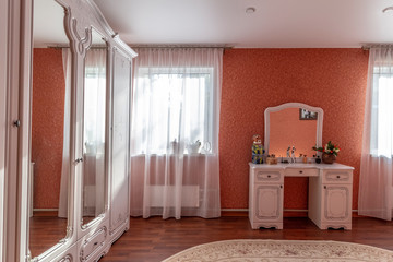 White antique furniture in a bedroom with red walls.