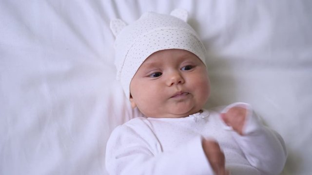Lovely baby girl babbling and playing with sweet tiny hands, happy childhood