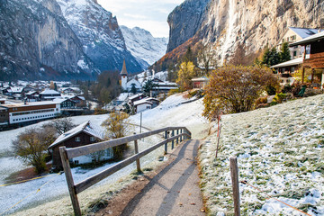 amazing touristic alpine village in winter with famous church and Staubbach waterfall ...