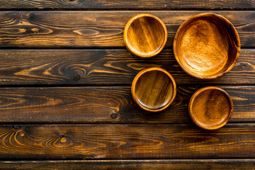 Making wooden dishes. Empty bowls on dark wooden background top view copy space