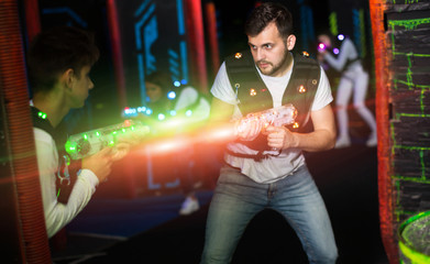 Excited guy laser tag player in bright beams