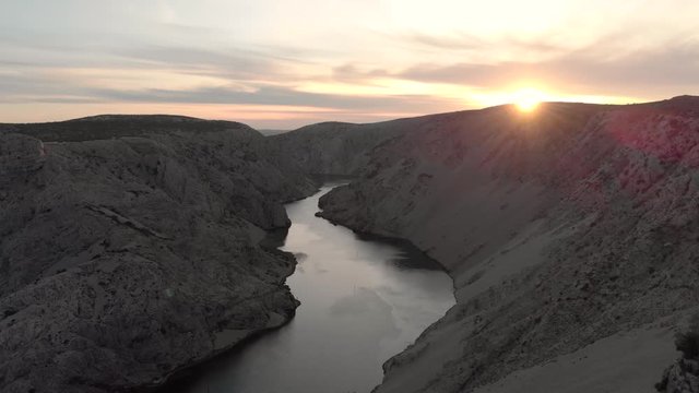 Drone fly above young man stand at the top of rocky cliff canion during sunset. Zrmanja river canyon Croatia.