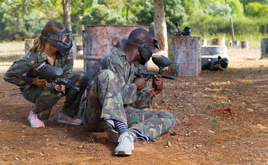 Fototapeta premium Two opposing teams shooting on paintball playing field outdoors