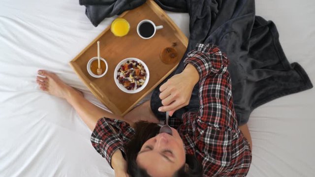 Close up Image from above of cute woman eating honey during the breakfast.