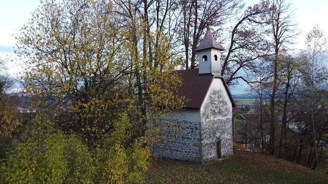 Small gothic chapel in the forest. A humble modest Christian church with no windows. Aerial drone video.