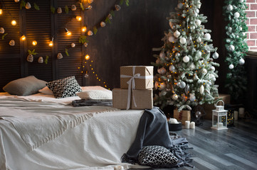 Christmas tree with white and black gifts in the bedroom Christmas. Beautifully decorated house with a silver, white and black tree and presents at Christmas. Magic time.