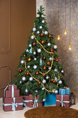 Christmas tree with blue and brown gifts in the white room Christmas. Beautifully decorated house with a silver, brown and blue tree and presents at Christmas.