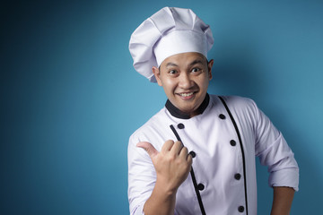 Happy Smiling Asian Chef Pointing Presenting Something on His Side