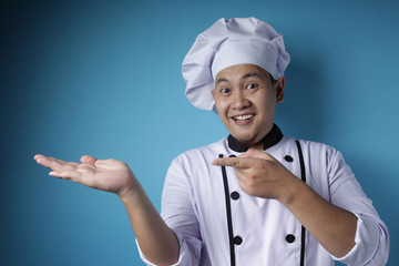 Happy Smiling Asian Chef Pointing Presenting Something on His Empty Hand