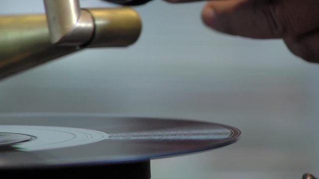 Male Hand Carefully Placing Needle on Vinyl in Gramophone - Close Up