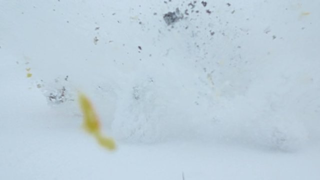 Two orange lie in snow, sad faces drawn on fruits skin. Right one suddenly explode and fly apart in mess with snow. Super slow motion shot. Small petard or squib explode inside sweet citrus