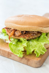 Homemade Salmon Burger with Tartar Sauce, Onion and Lettuce on Marble Board.
