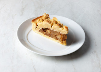 Delicious crumble apple cake on a white plate