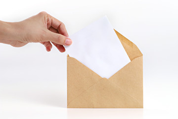 Hand holding blank card with brown envelope on white background