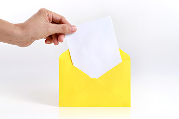 Hand holding blank card with yellow envelope on white background