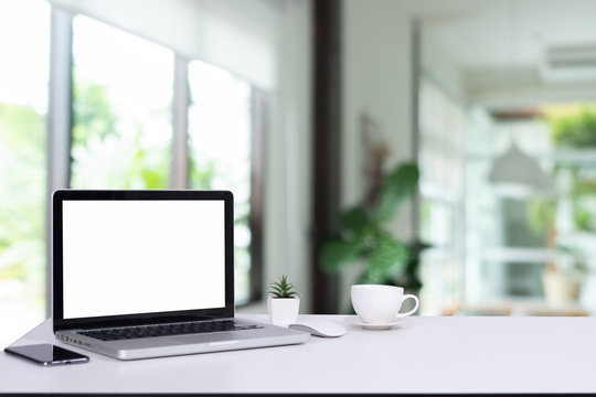 Computer notebook and mouse with a coffee shop behind the