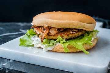 Homemade Salmon Burger with Tartar Sauce, Onion and Lettuce on Marble Board.