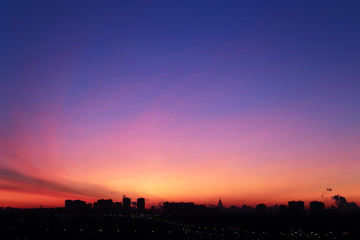 Sunrise over the city, scenic view. Pink-blue sky in soft colors sky above silhouettes of high-rise buildings, colorful cityscape for background