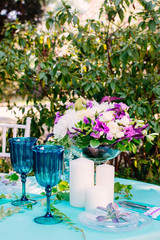 Blue glasses on decorated wedding table. Wheat, lemons on background. Reception. Yellow and blue tablecloth