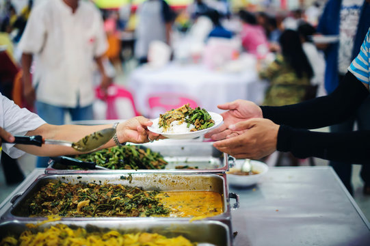 Warm Food Scooped From Ladle Into A Container Of The Poor: The Concept Of Giving