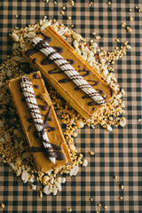 Piece of cake with nuts and caramel on rustic background