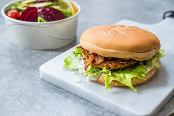 Fast Food Menu Salmon Burger with Take Away Salad in Plastic Box.