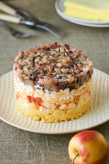 Layered salad with salted herring and apples